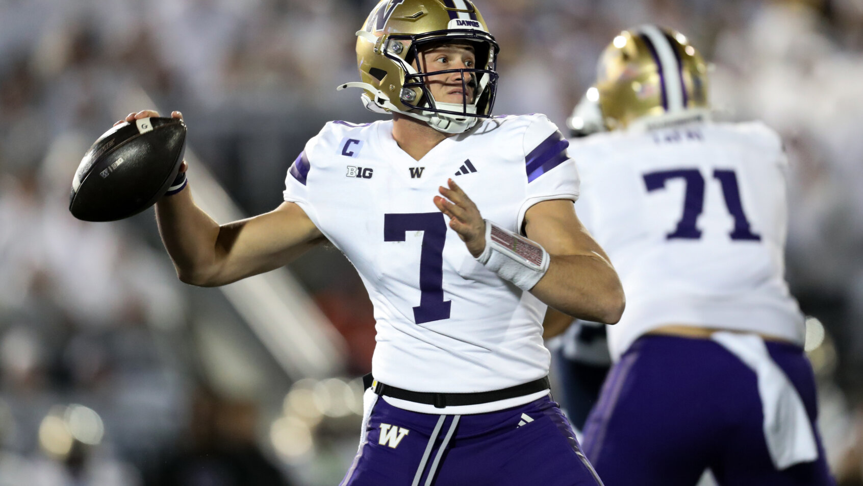 quarterback throws football in stadium