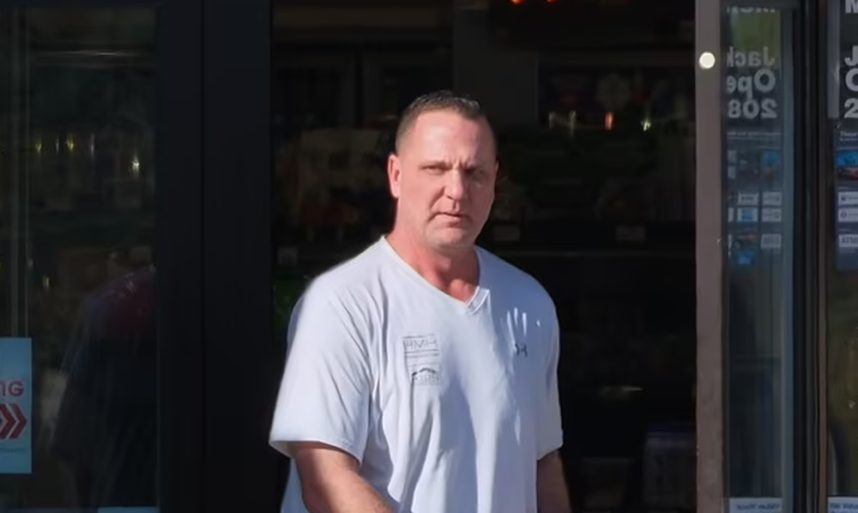 Man in white shirt by door