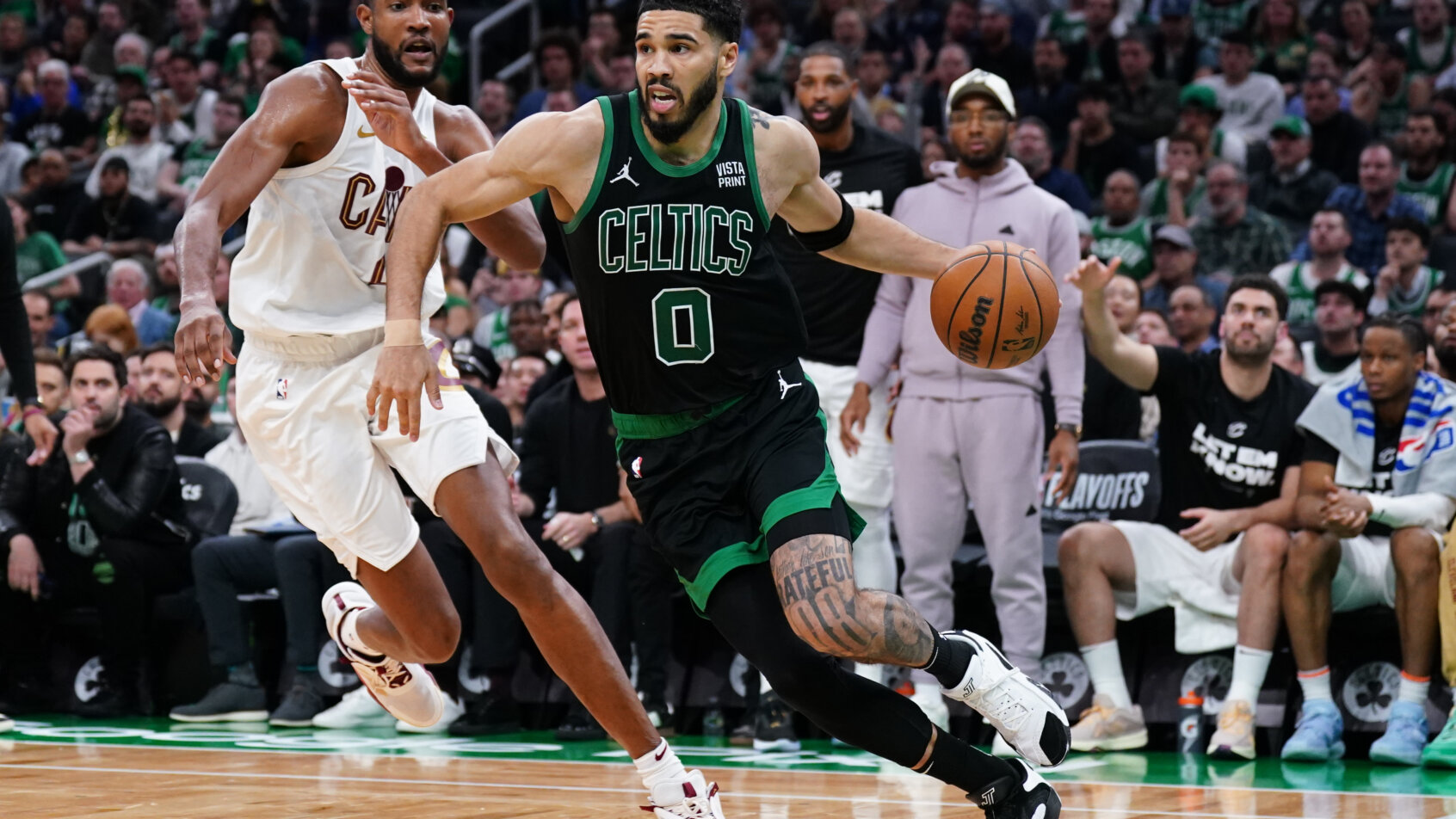 Jayson Tatum dribbling past defender