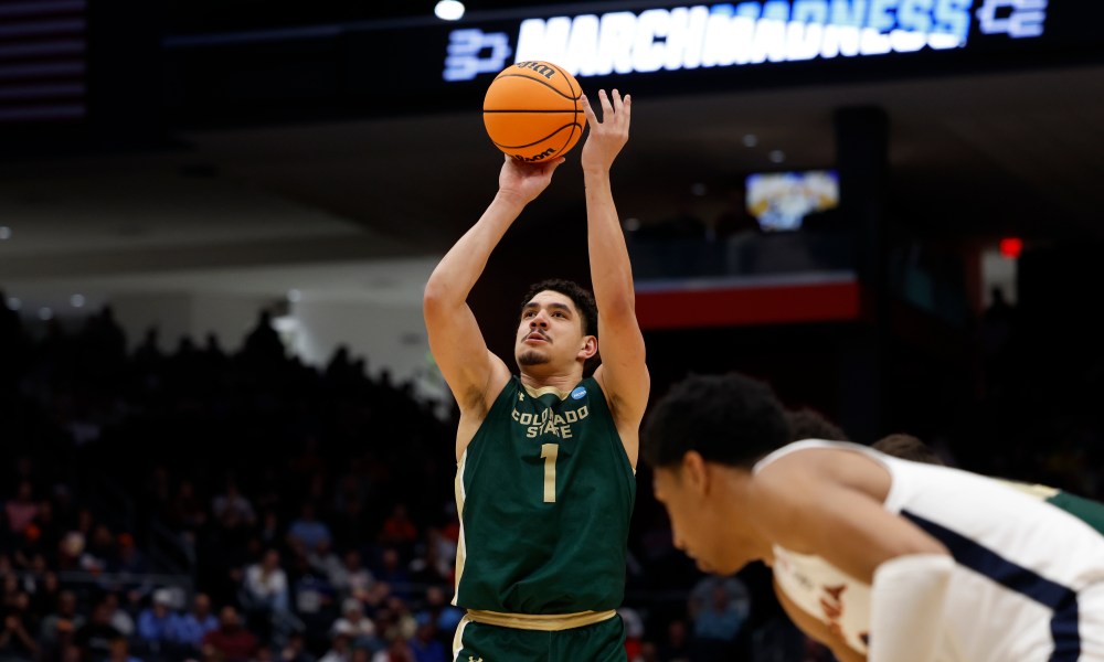 Basketball player shoots toward basket