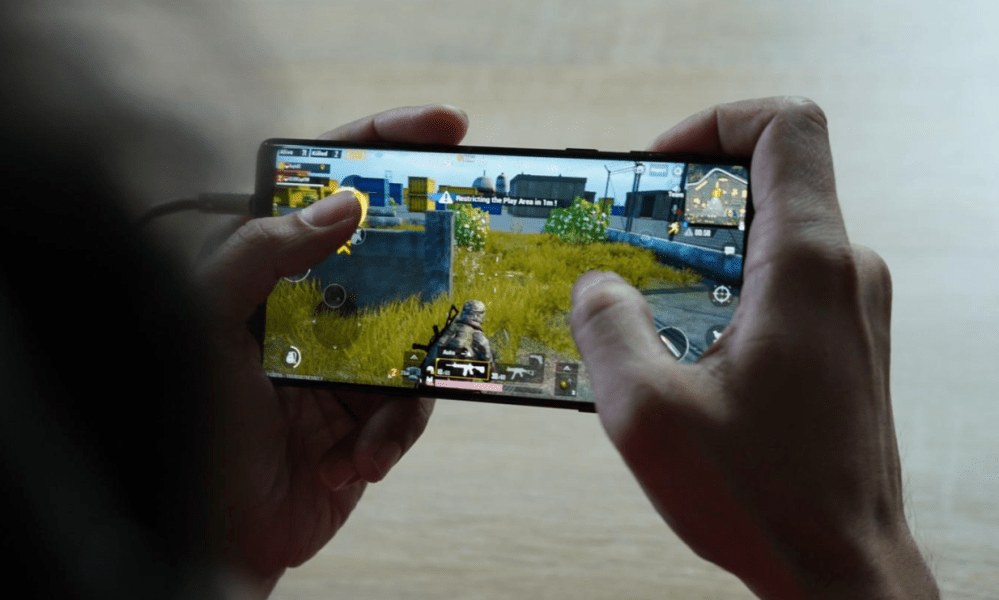 Hand holding phone showing game screen