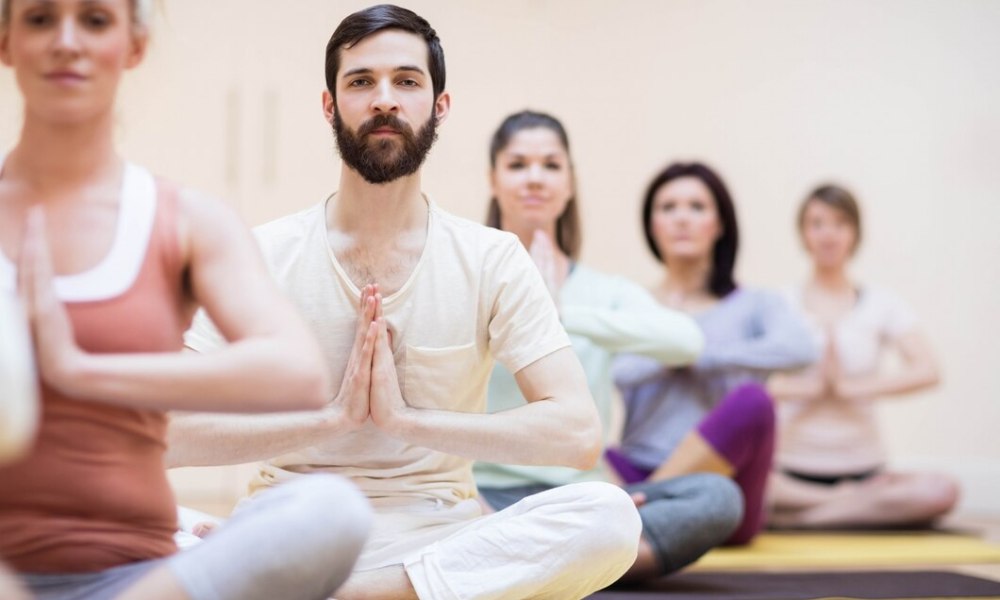 People in lotus position meditating together