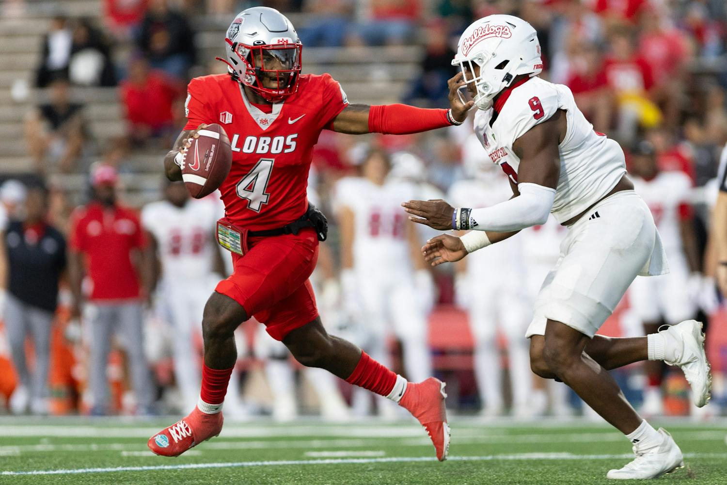 Red uniformed player sprinting with football