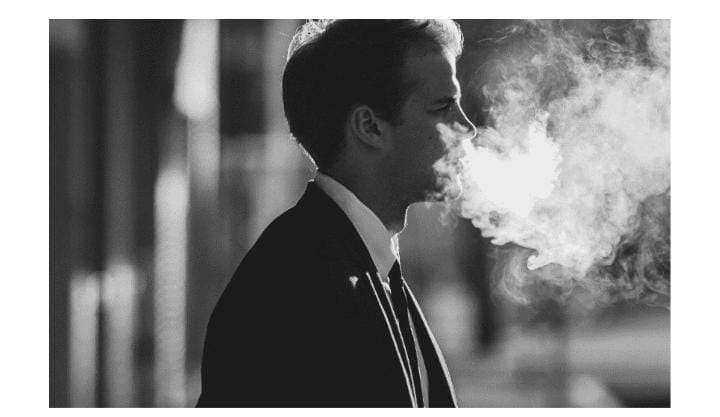 Man exhaling cigarette smoke