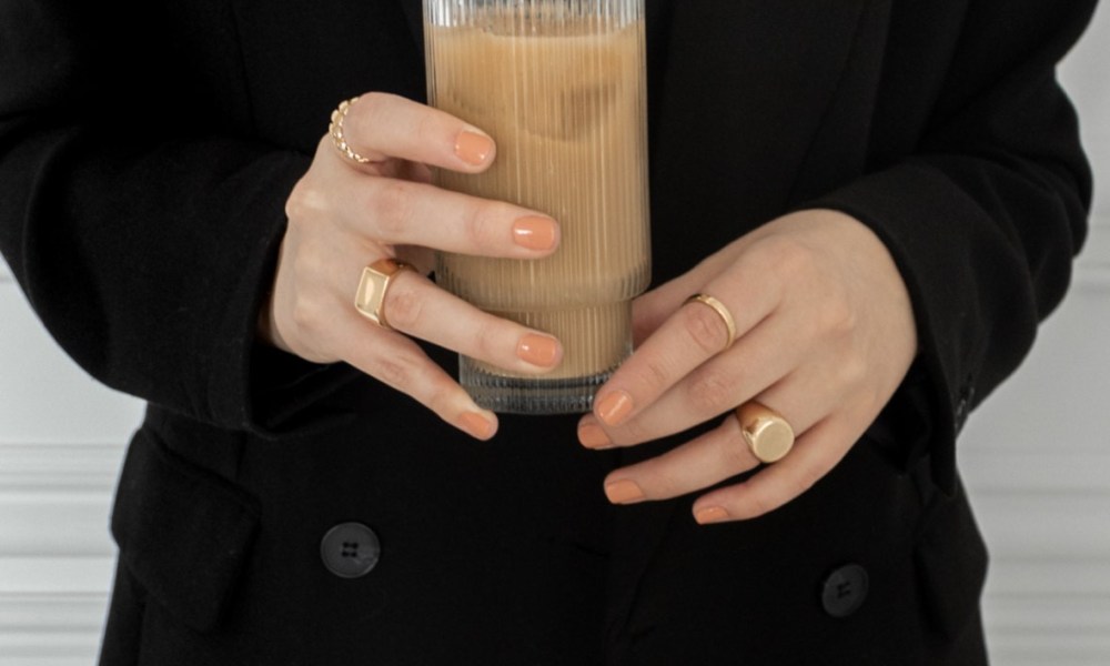 Woman with iced coffee and jewelry