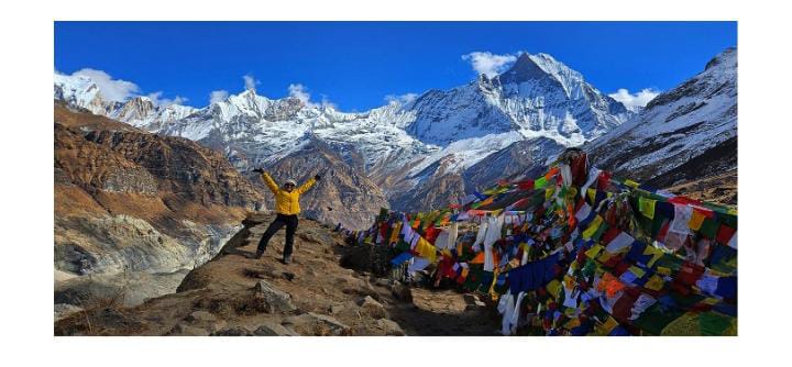 Person leaping by Tibetan prayer flags