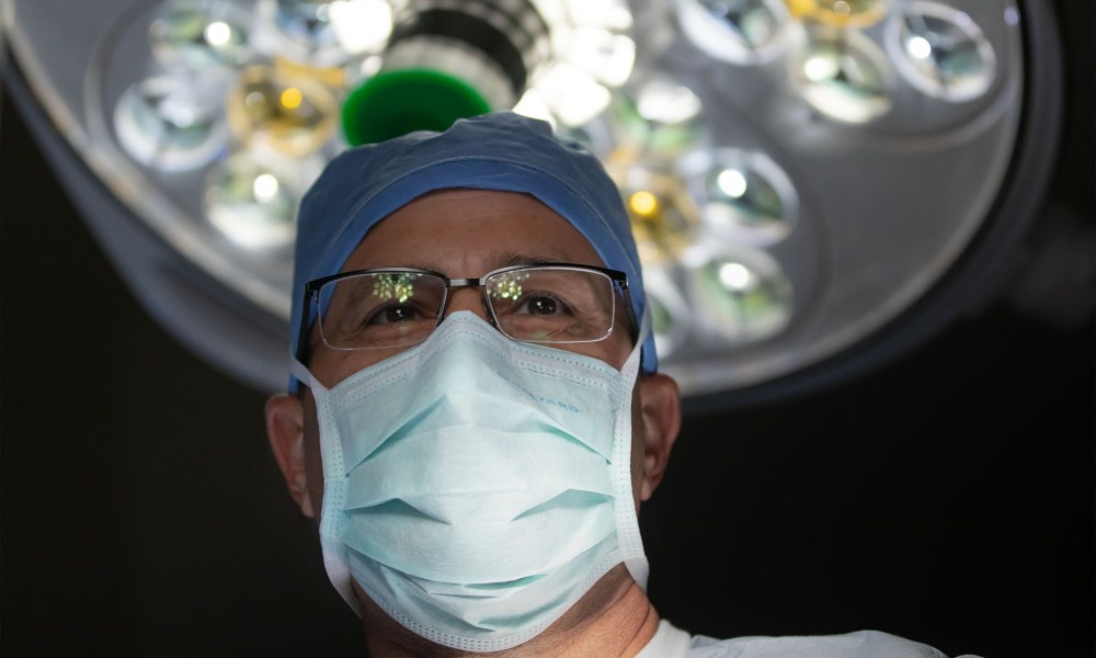 Doctor in surgical mask under light