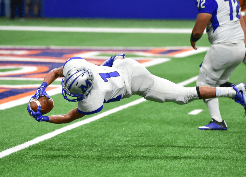 Football player diving at ground