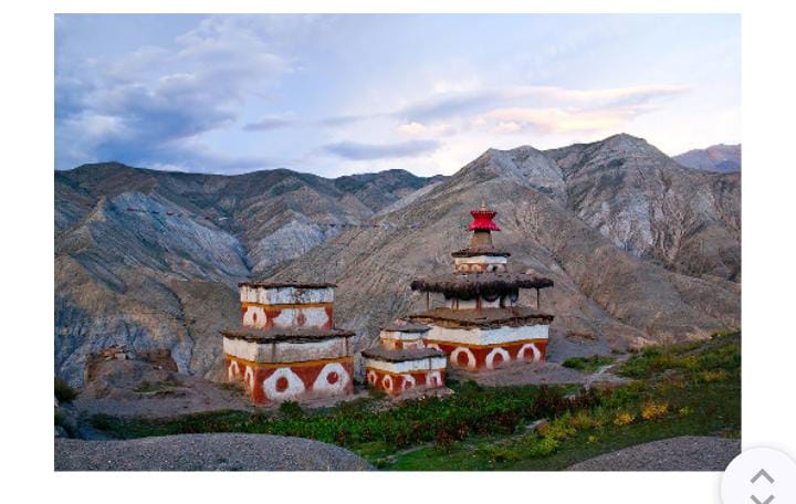 Two buildings against mountain landscape