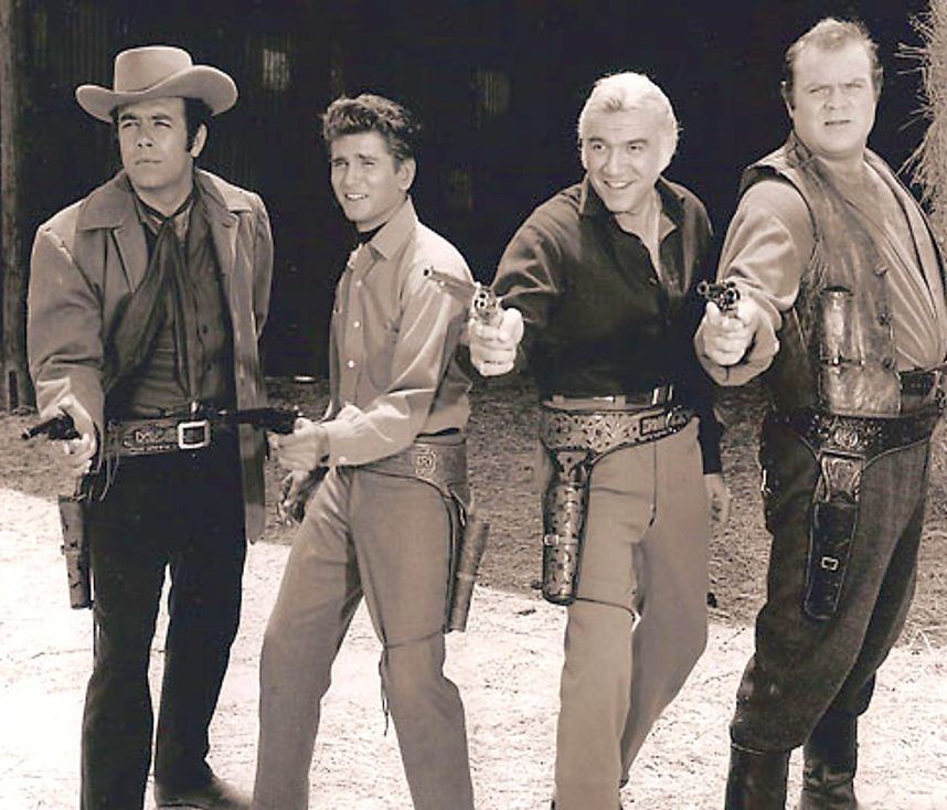 Four armed cowboys posing together