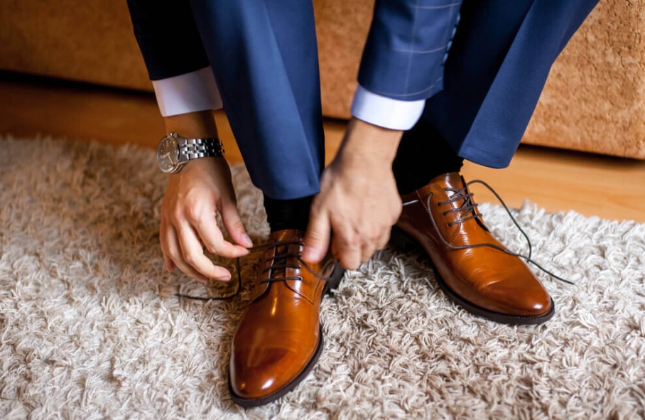 Man tying brown shoes