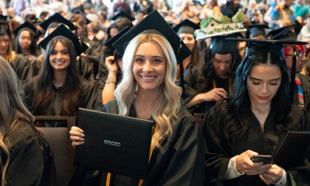 Graduate holding diploma and smiling