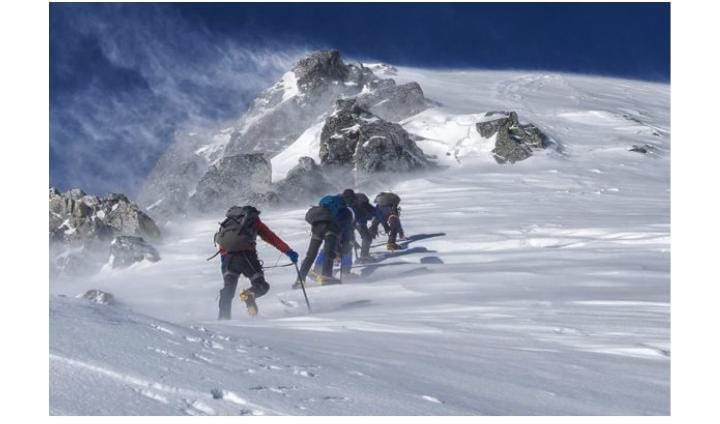 Mountain climbers ascending snowy peak