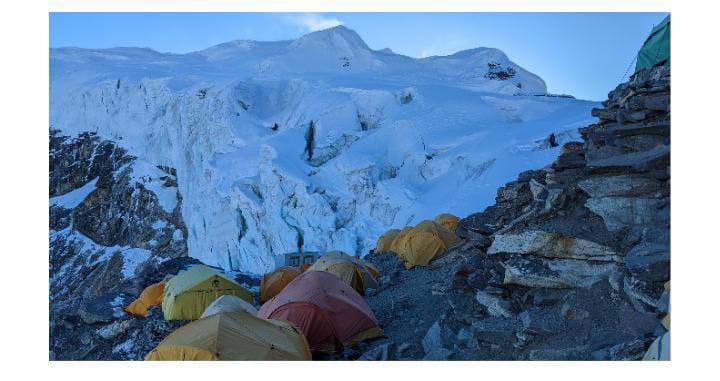 Tents below mountain landscape