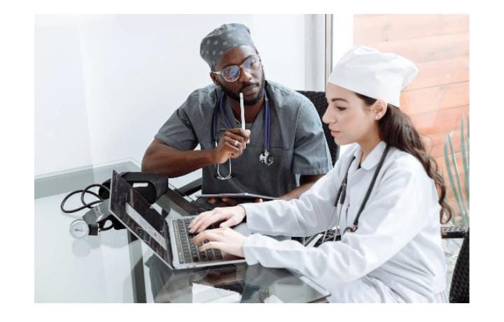 Healthcare professionals reviewing laptop together