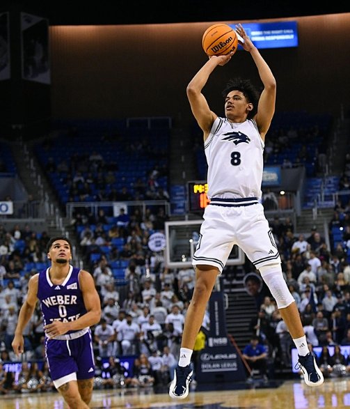 Player dunking basketball mid-air