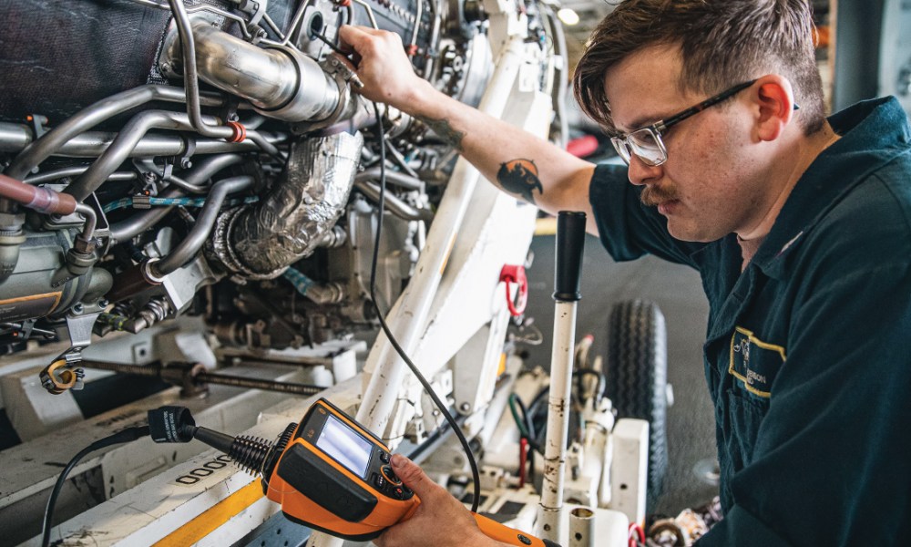 Mechanic using borescope on engine