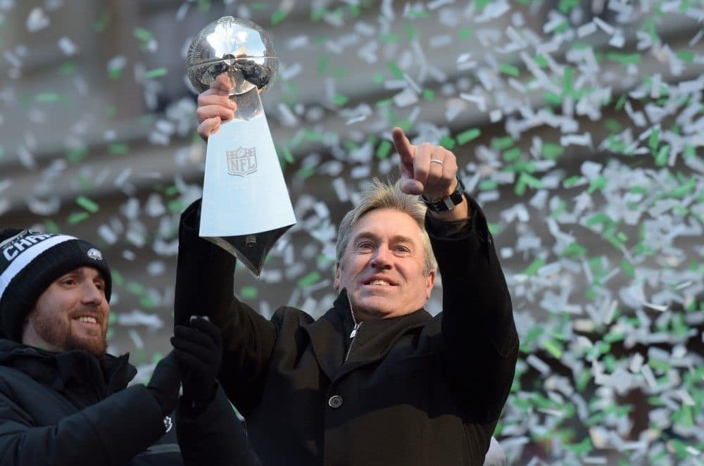 NFL coach holding championship trophy