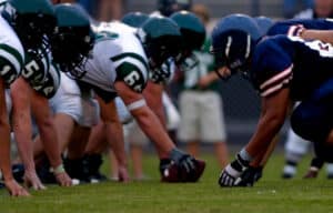 Alt Text: Football players lined up pre-game