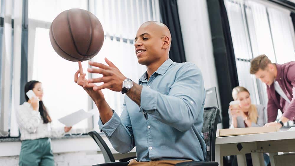 man throwing basketball in office