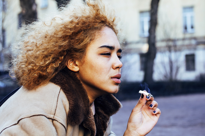 Woman tries first cigarette, shows discomfort