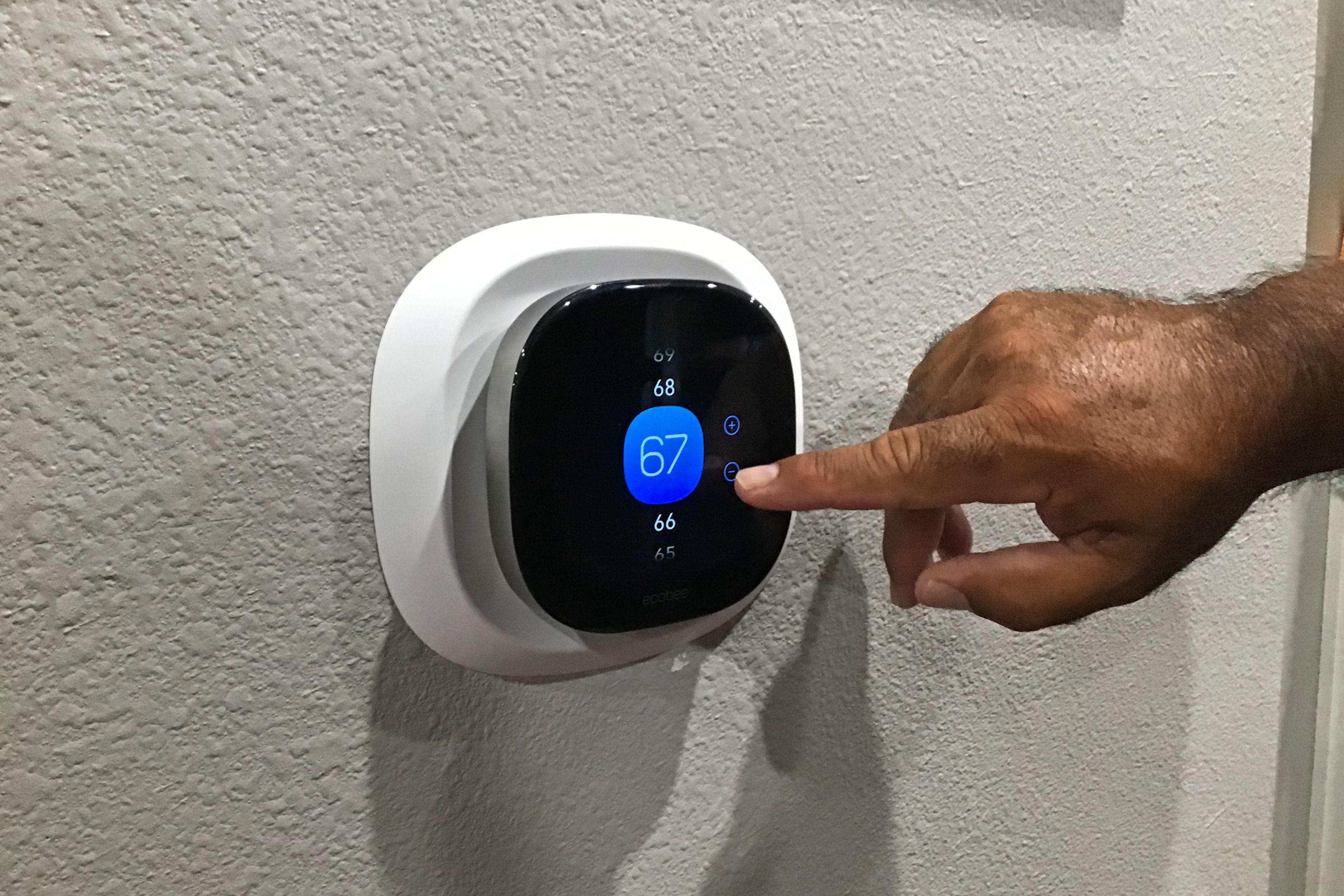 Hand adjusting Ecobee smart thermostat