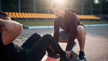 Athletic trainer assisting injured athlete