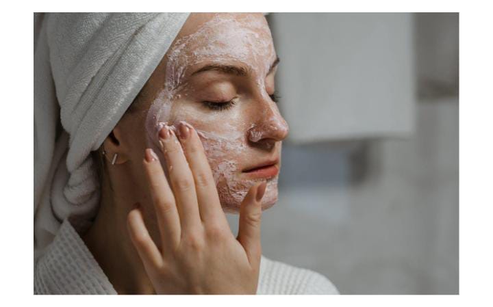 Woman applying face mask during skincare