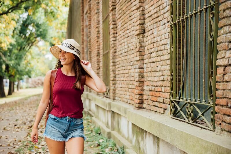 Woman walking in hat and shorts