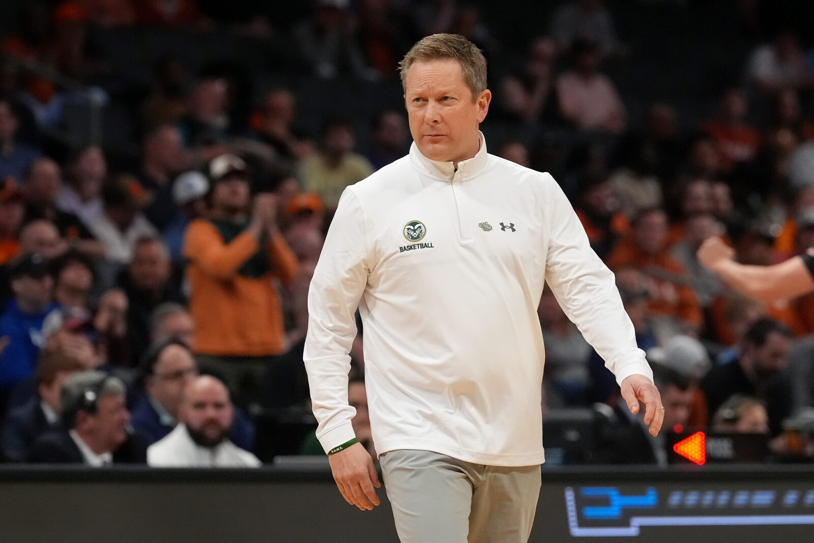 Coach wearing white quarter-zip pullover