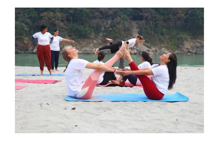 Women doing yoga on beach