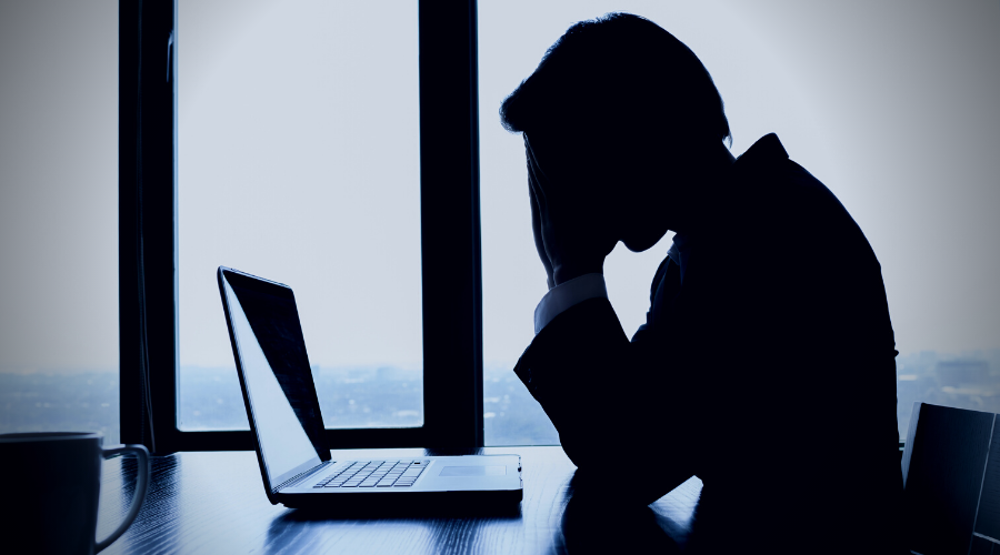 Silhouette of person at computer desk