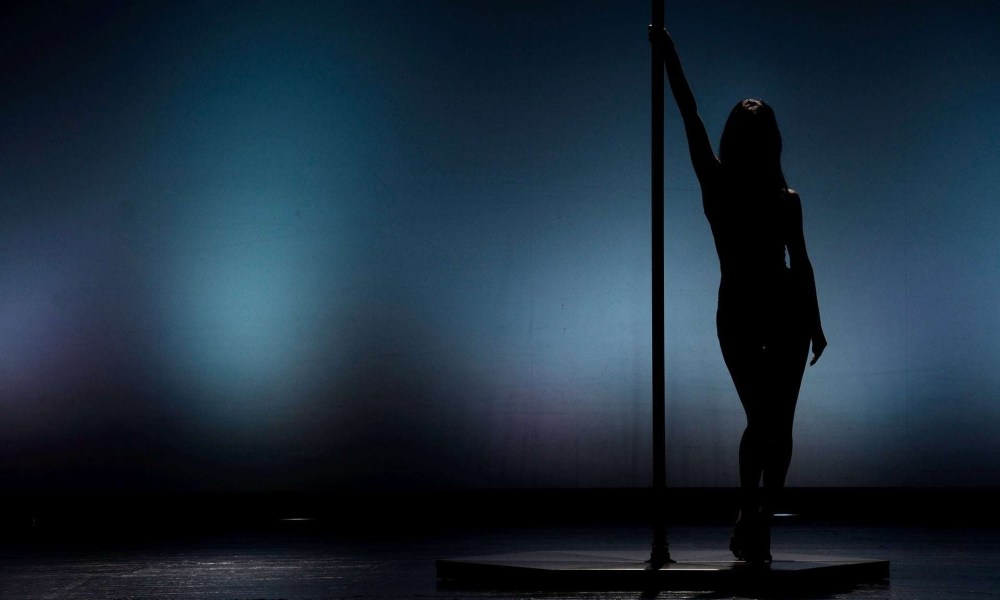 Silhouette of pole dancer performing