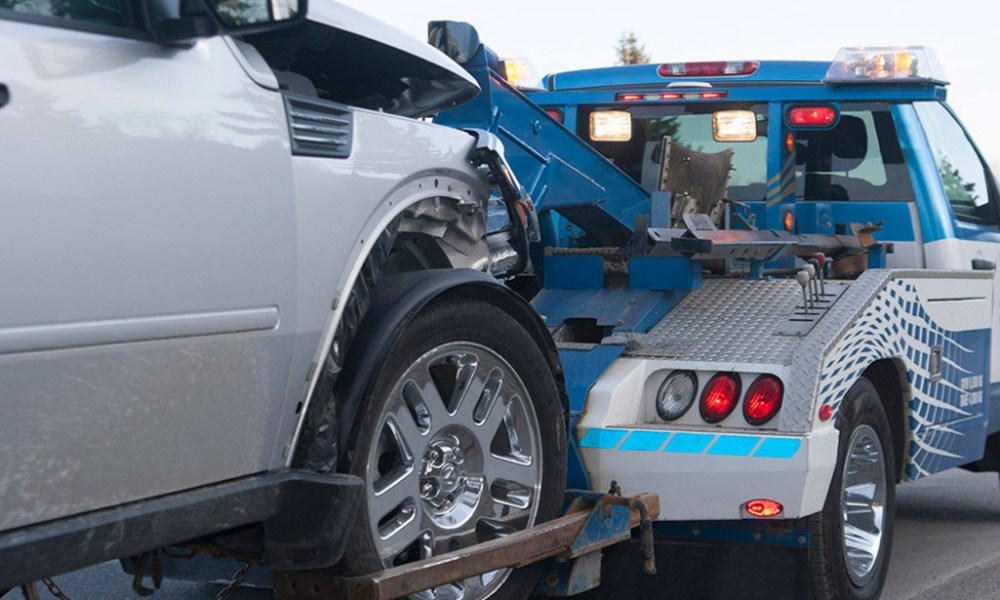 Tow truck hauling white vehicle