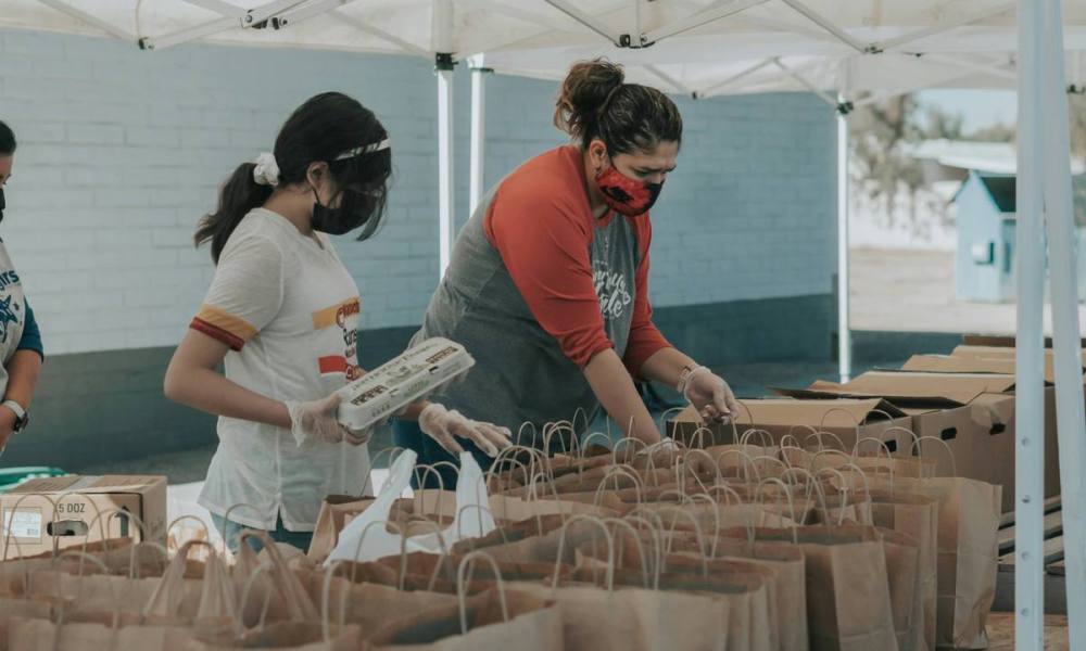 Masked women organizing shopping bags