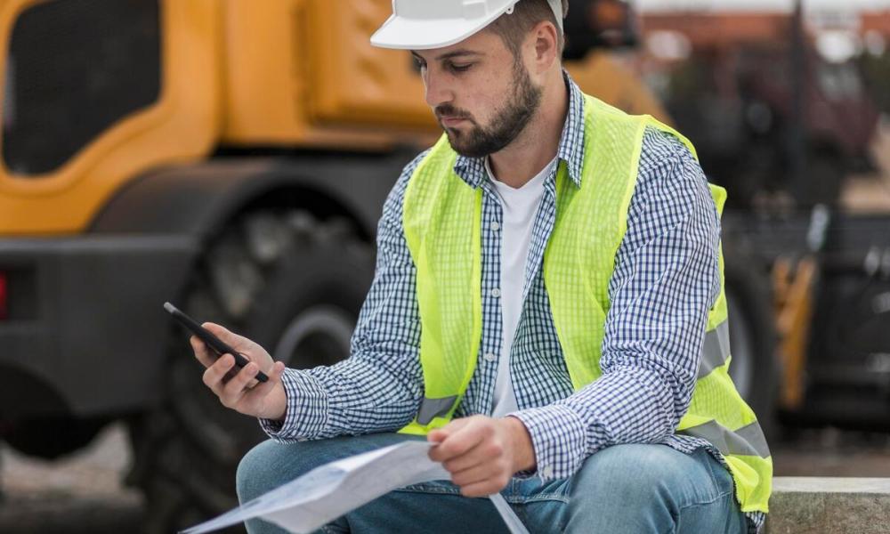 Construction worker checking phone