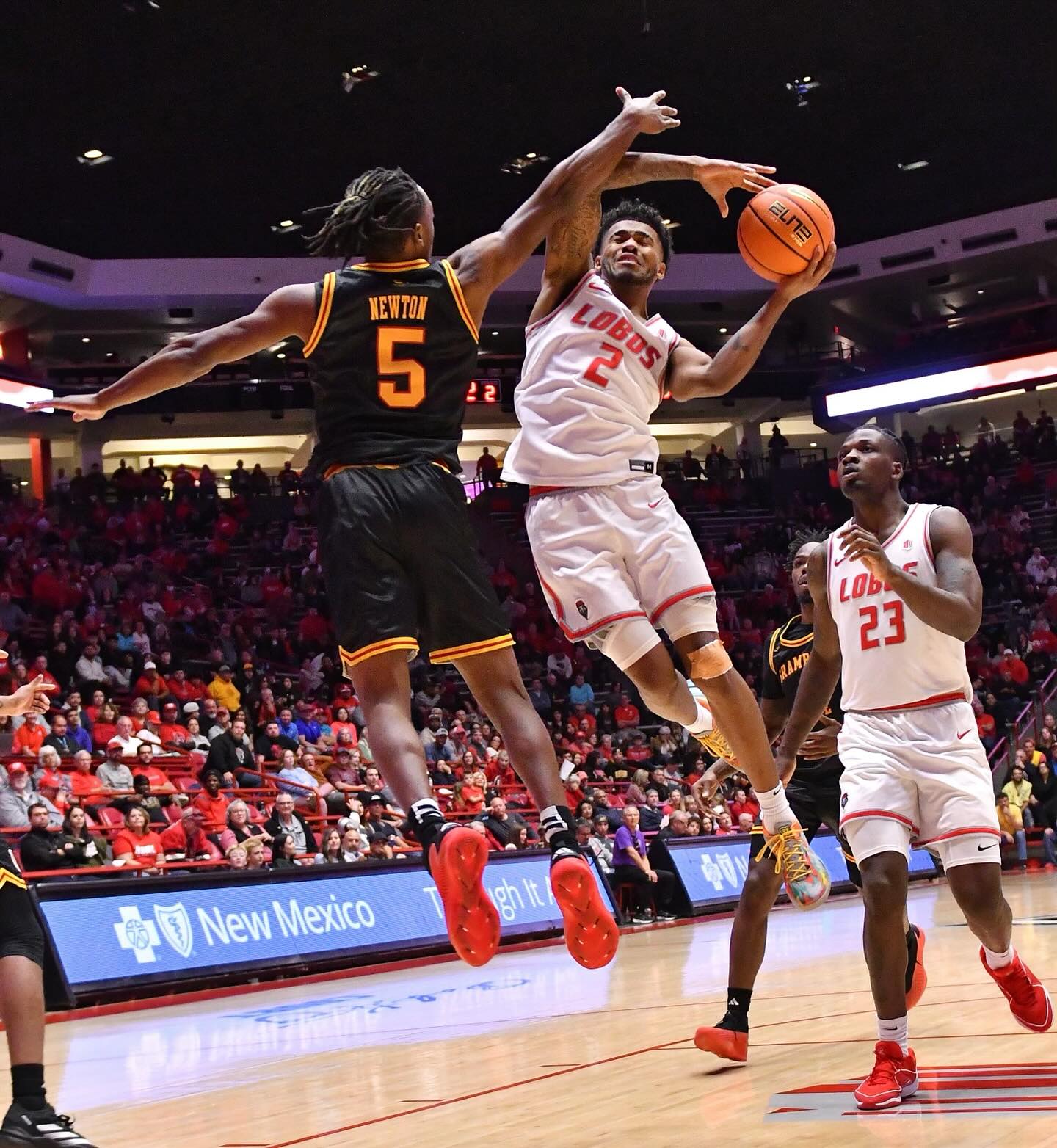 Player shooting basketball mid-jump