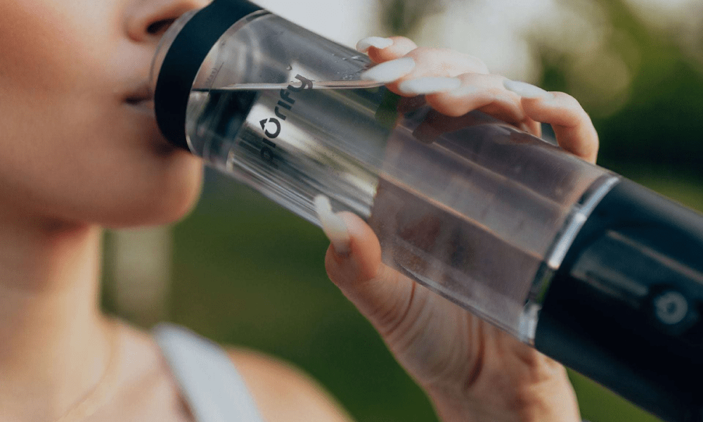 Woman drinking from hydrogen water bottle