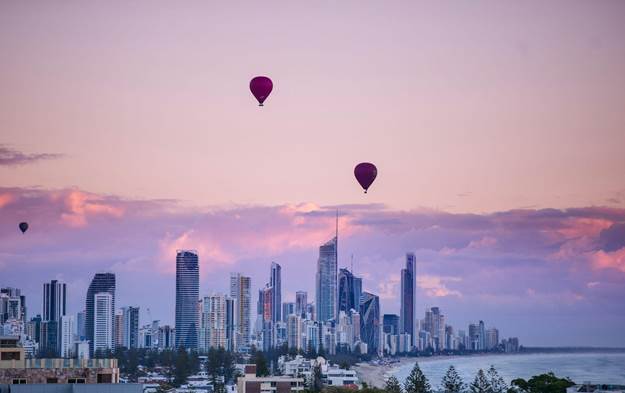 Colorful balloons float above city